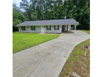 Charming single story home featuring a covered carport and a long driveway at 3645 Shrewsbury Ct, Snellville, GA 30039