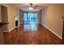 Spacious living room with hardwood floors, fireplace, and sliding glass doors to a balcony at 2303 Pine Heights Ne Dr, Atlanta, GA 30324