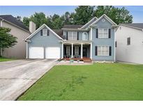 Charming two-story home featuring a well-manicured lawn, a two-car garage, and a welcoming front porch at 4321 Clairesbrook Ln, Acworth, GA 30101