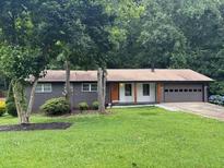 Charming single story home featuring a front lawn, mature trees, and attached garage at 4325 Dawning Ln, Douglasville, GA 30135