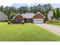 Charming brick home with a well-manicured lawn and an attached two-car garage at 2905 Ivey Ridge Ln, Roswell, GA 30076