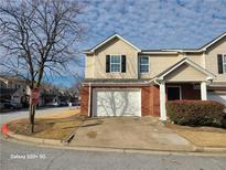Charming two-story townhome featuring a brick facade and an attached single-car garage at 303 Tara Commons Circle Cir, Loganville, GA 30052