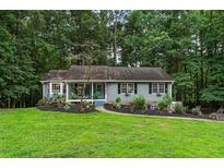 Charming single-story home with blue siding, black shutters, and a well-manicured front yard at 3861 Riding Sw Trl, Powder Springs, GA 30127