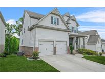 Side view of a two-story home featuring an attached two-car garage and well-maintained lawn at 4110 Morgan Elizabeth Way, Cumming, GA 30041