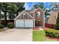 Charming two-story home featuring a two-car garage, manicured lawn, and a blend of siding and brick facade at 914 Wenham Ln, Lawrenceville, GA 30044
