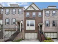 Brick townhouse exterior with multiple stories, a garage, and staircase up to the front door at 1935 Cobblestone Ne Cir, Brookhaven, GA 30319