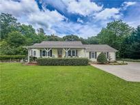 Charming one-story home featuring a well-manicured lawn, inviting porch, and a beautiful fountain at 4017 S South Bogan Road Rd, Buford, GA 30519