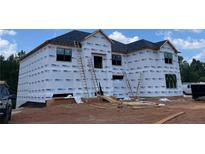 New home construction featuring a house wrapped in weather resistant material and ladders at 3063 Reserve Ct Sw, Conyers, GA 30094