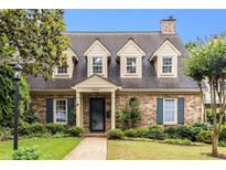 Charming brick home with dormer windows, a walkway, and professionally landscaped yard at 1508 Brianwood Rd # 1508, Decatur, GA 30033