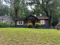 Charming one-story home with a freshly painted exterior, a well-manicured lawn, and mature trees at 1846 North Ave, Atlanta, GA 30318