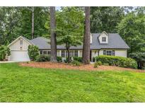 Charming home with a well-maintained lawn, inviting curb appeal, attached garage and mature trees at 229 Devonwood Dr, Atlanta, GA 30328