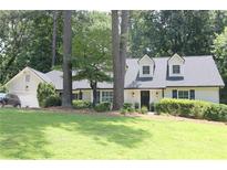 Charming one-story home with dormer windows, a well-manicured lawn, and mature trees at 229 Devonwood Dr, Atlanta, GA 30328