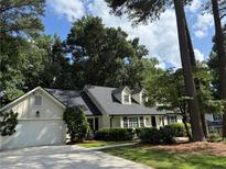 Charming single Gathering home with a beautifully landscaped front yard and a well-maintained driveway at 229 Devonwood Dr, Atlanta, GA 30328