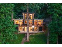 Contemporary home with expansive windows and a large deck nestled amongst mature trees at 132 Lakeshore Dr, Roswell, GA 30075