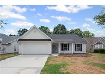 Charming one-story home with white siding, a two-car garage, and a well-maintained front lawn at 2470 Hillvale Cir, Lithonia, GA 30058