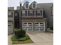 Charming two-story brick townhouse with a two-car garage and well-maintained landscaping at 228 Stone Park Dr, Woodstock, GA 30188