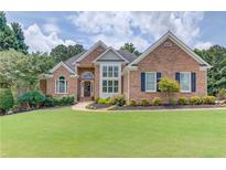 Charming brick home featuring manicured lawn and mature landscaping at 3072 Parks Run, Loganville, GA 30052