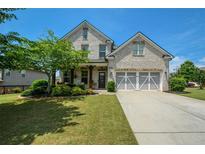Charming two-story brick home with a well-manicured lawn and a two-car garage at 4265 Pleasant Woods Dr, Cumming, GA 30028