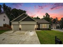 Charming one-story home with a two-car garage and inviting curb appeal, set against a colorful sunset backdrop at 122 Riverbirch Way, Dallas, GA 30157