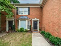 Charming brick townhome featuring manicured lawn and inviting front entrance at 50 Mount Vernon Cir, Atlanta, GA 30338