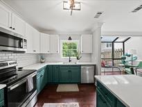 Modern kitchen features two-tone cabinets, stainless steel appliances, and a window overlooking greenery at 50 Mount Vernon Cir, Atlanta, GA 30338