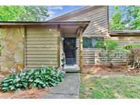 Charming home featuring a stone facade, wood siding, and a well-maintained front garden at 830 Bonnie Glen Se Dr, Marietta, GA 30067