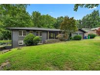 Charming single-story house features a brick facade and a lush green lawn at 2661 Fleur De Lis Pl, Atlanta, GA 30360