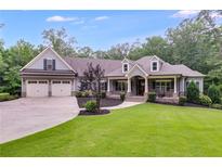 Charming home featuring a manicured lawn, inviting front porch, and a spacious two-car garage at 7269 Tyree Rd, Winston, GA 30187