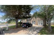 Two-story brick home with double French doors and driveway, partially obscured by trees at 11526 Registry Blvd, Hampton, GA 30228