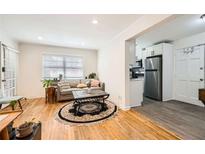 Inviting living room featuring hardwood floors, a comfortable sofa, and an open layout connected to the kitchen at 1284 Piedmont Ne Ave # 12, Atlanta, GA 30309