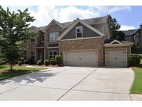 Two-story brick home featuring a two-car garage and a well-maintained lawn at 1365 Slate Bend Dr, Dacula, GA 30019