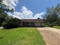 A single story home with a well manicured front yard and a driveway leading up to the garage and covered parking at 3217 Canterbury Trl, Rex, GA 30273