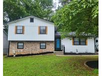 Charming two-story home with stone accents, fresh white siding, and a well-manicured lawn at 6118 Dana Ct, Lithonia, GA 30058