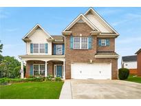 Charming brick two-story home with a well-manicured lawn and vibrant blue shutters at 872 Misty View Ct, Lilburn, GA 30047
