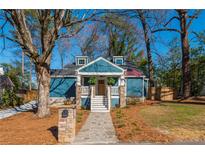 Charming blue home with stone accents, landscaped yard and American flag at 1555 Steele Nw Dr, Atlanta, GA 30309