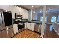 Modern kitchen featuring stainless steel appliances, white cabinetry, and hardwood floors at 793 Inman Mews Ne Dr, Atlanta, GA 30307