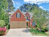 Beautiful brick home with a well-manicured lawn, two-car garage, and charming front yard landscaping at 25 Nunnally Pl, Villa Rica, GA 30180