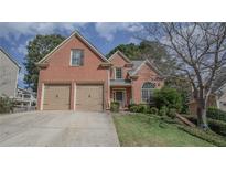 Charming two-story brick home featuring an attached two-car garage and well-maintained lawn at 25 Nunnally Pl, Villa Rica, GA 30180