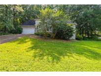 Traditional home featuring an attached two car garage, an ample front yard and mature landscaping at 402 John Tate Nw Rd, Acworth, GA 30102