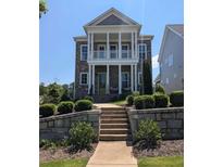 Stunning two-story home with brick facade, stately columns, second story balcony and manicured landscaping at 545 Hanlon Way, Alpharetta, GA 30009