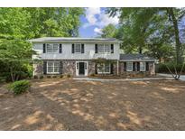 Charming two-story home with brick and siding exterior, black shutters, and well-manicured landscaping at , Dunwoody, GA 30338