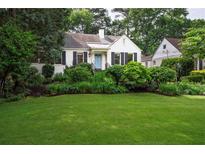 Charming white home with a well-manicured front yard and vibrant landscaping at 657 E Paces Ferry Ne Rd, Atlanta, GA 30305