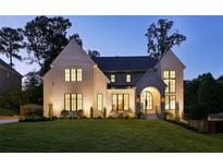 Elegant home exterior features a manicured lawn and striking architectural details, perfectly illuminated at twilight at 1312 Becket Ne Dr, Brookhaven, GA 30319