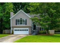Charming two-story home features a manicured lawn, attached garage and beautiful landscaping at 5137 Allison Way, Sugar Hill, GA 30518