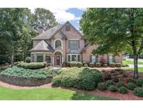 Charming brick two-story home with a beautifully landscaped front yard and inviting curb appeal at 1720 Monarch Ct, Cumming, GA 30041