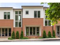 Charming townhome exterior with brick and white siding, featuring a welcoming entryway and well-maintained landscaping at 10904 Serenbe Ln, Chattahoochee Hills, GA 30268