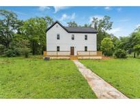 Charming two-story home with a dark roof and newly installed light-colored wood deck at 331 Highway 162, Covington, GA 30016