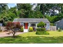 Charming blue home with a bright red door and a well-manicured lawn with lush landscaping at 1090 Shepherds Ne Ln, Atlanta, GA 30324