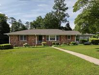 Charming brick home featuring a lush green lawn and mature trees at 286 Sequoia Ne Dr, Marietta, GA 30060