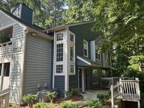 Two-story home with gray and blue siding, white trim, large windows, and front yard foliage at 1404 N Crossing Ne Dr, Atlanta, GA 30329
